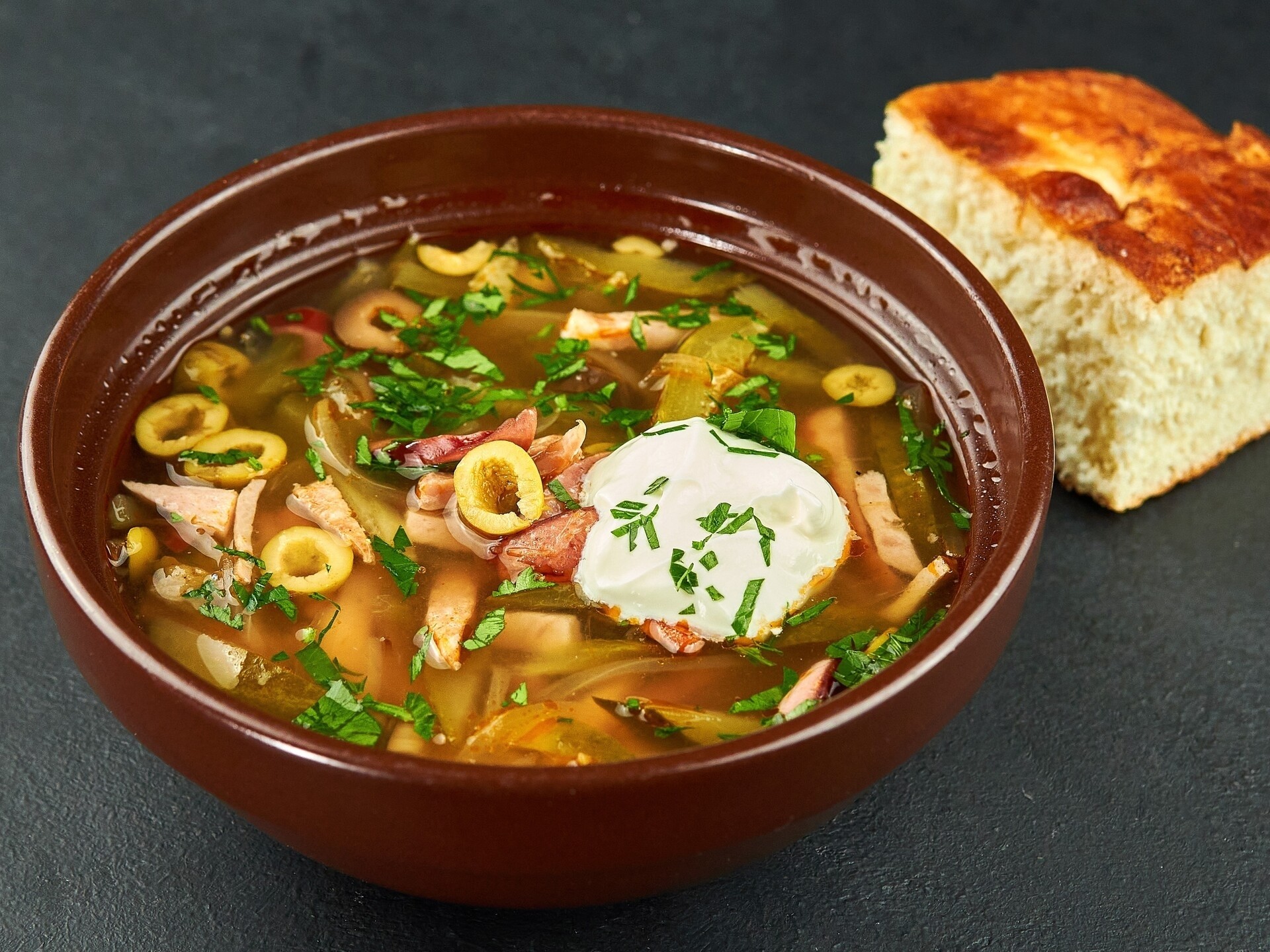 Мясная солянка с открытого огня со сметаной и хлебом